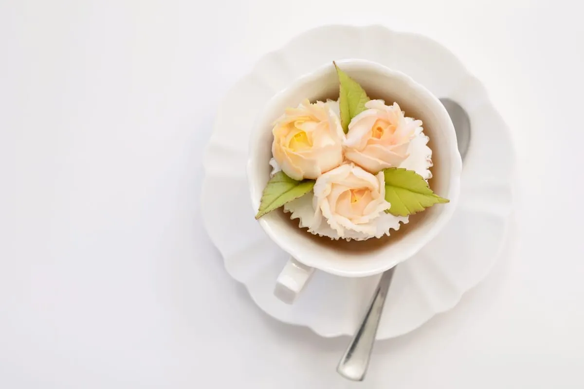 Peach buttercream roses in a white teacup