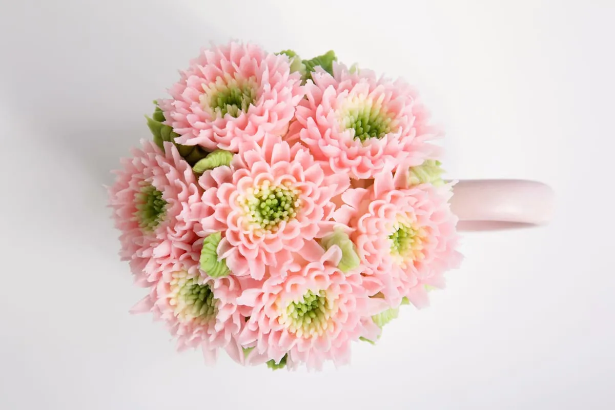 Pink buttercream chrysanthemums in a mug